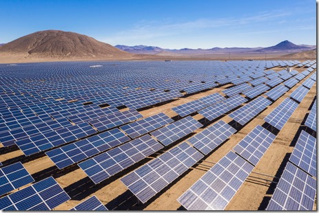 Aerial view of hundreds solar energy modules or panels rows along the dry lands at Atacama Desert, Chile. Huge Photovoltaic PV Plant in the middle of the desert from an aerial drone point of view