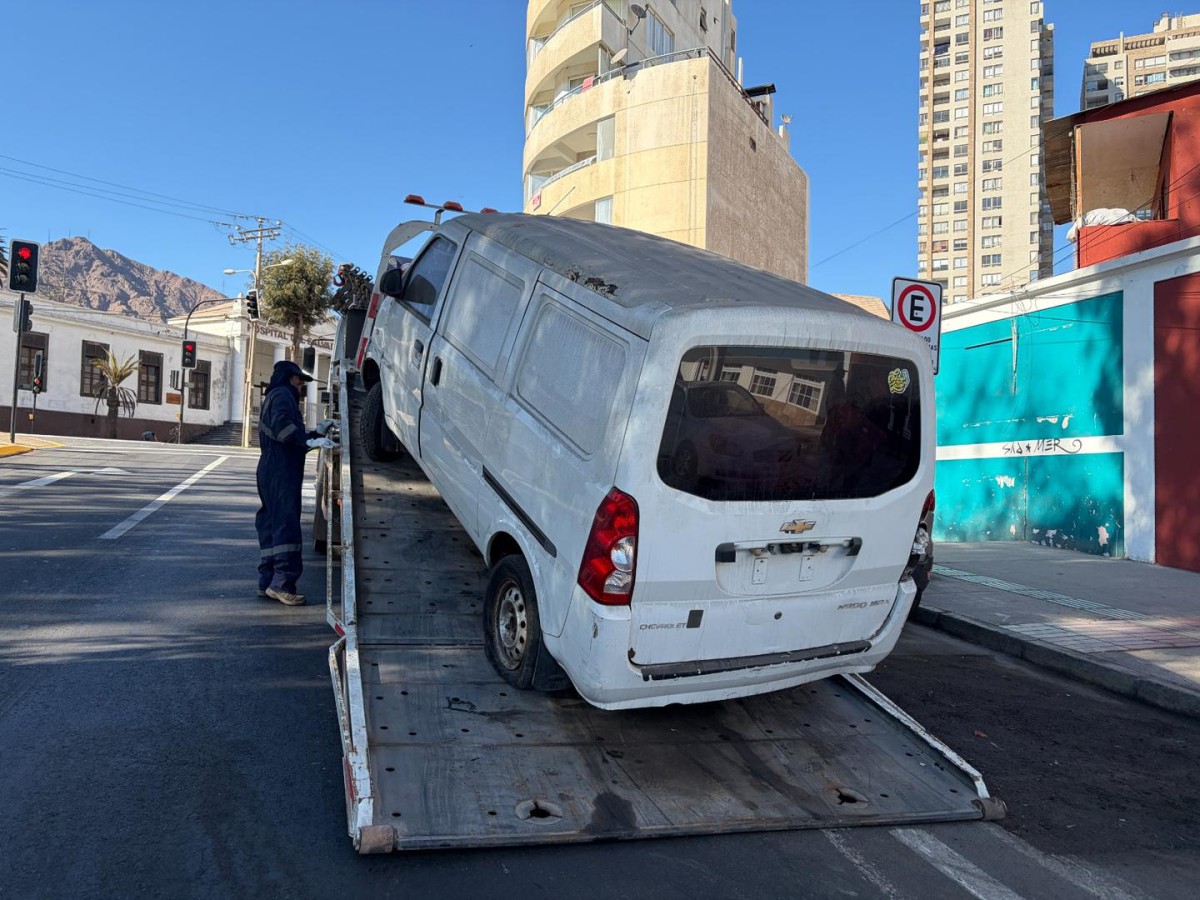 OPERATIVOS MUNICIPALES RETIRAN VEHÍCULOS ABANDONADOS EN ANTOFAGASTA Personal municipal realizando el retiro de un vehículo abandonado en una calle de Antofagasta.