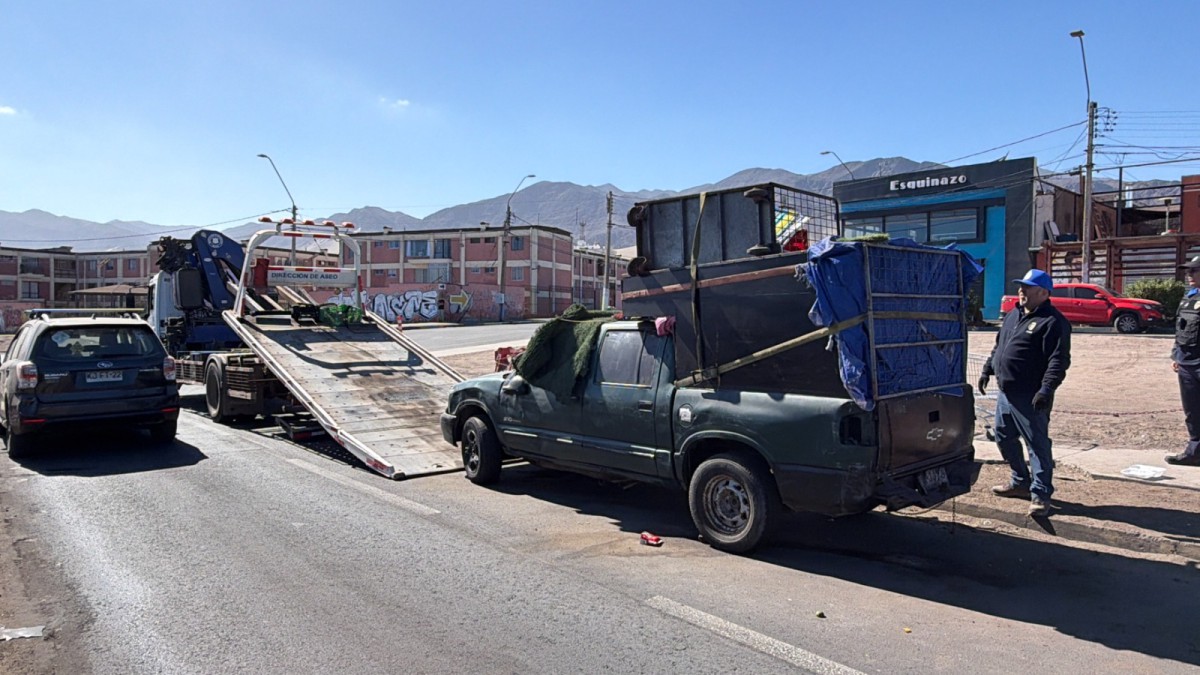 OPERATIVOS MUNICIPALES RETIRAN VEHÍCULOS ABANDONADOS EN ANTOFAGASTA Personal municipal realizando el retiro de un vehículo abandonado en una calle de Antofagasta.