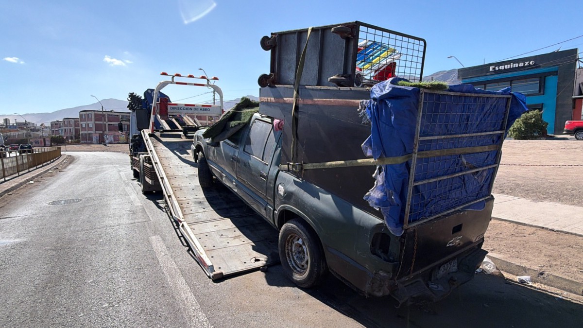 OPERATIVOS MUNICIPALES RETIRAN VEHÍCULOS ABANDONADOS EN ANTOFAGASTA Personal municipal realizando el retiro de un vehículo abandonado en una calle de Antofagasta.