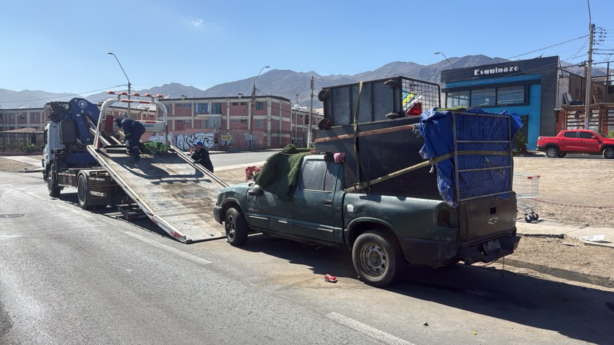 OPERATIVOS MUNICIPALES RETIRAN VEHÍCULOS ABANDONADOS EN ANTOFAGASTA Personal municipal realizando el retiro de un vehículo abandonado en una calle de Antofagasta.