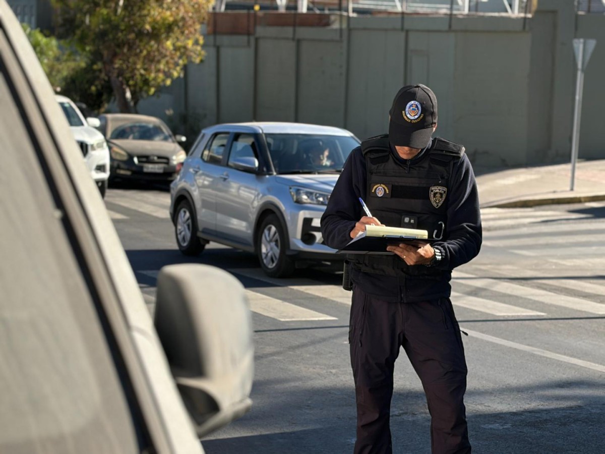 OPERATIVOS MUNICIPALES RETIRAN VEHÍCULOS ABANDONADOS EN ANTOFAGASTA Personal municipal realizando el retiro de un vehículo abandonado en una calle de Antofagasta.