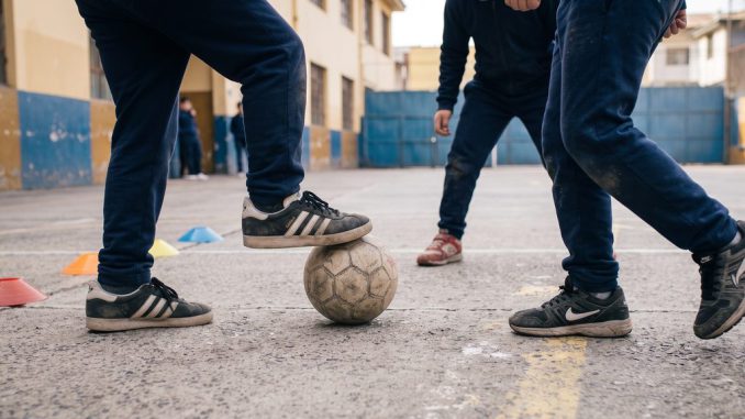 Estudiantes participando en actividades físicas y juegos recreativos en un patio escolar chileno