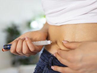 Persona midiendo su cintura con una cinta métrica simbolizando el efecto de medicamentos GLP-1