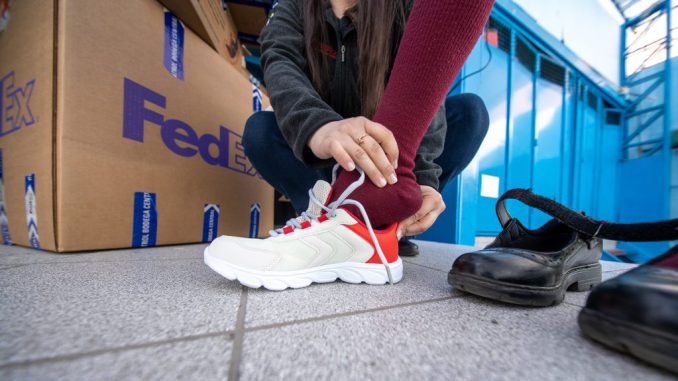 Estudiantes recibiendo donaciones de zapatillas y abrigos por parte de FedEx y Desafío Levantemos Chile