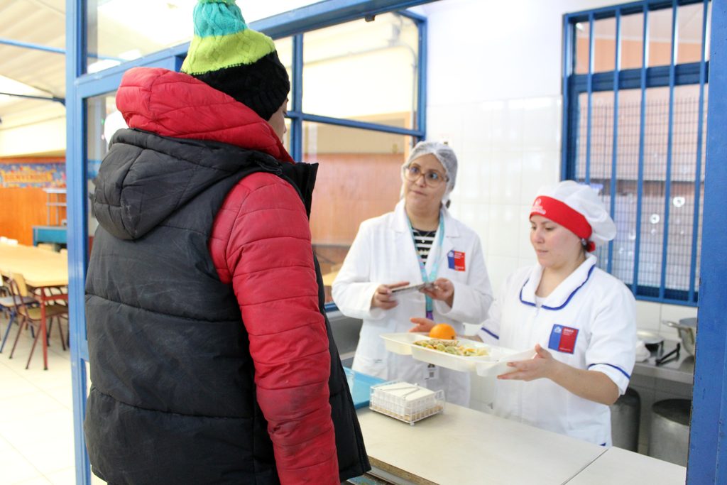 Personal de Junaeb entregando alimentación caliente en albergues habilitados tras el sistema frontal en Antofagasta.