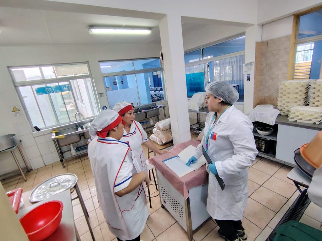 Personal de Junaeb entregando alimentación caliente en albergues habilitados tras el sistema frontal en Antofagasta.