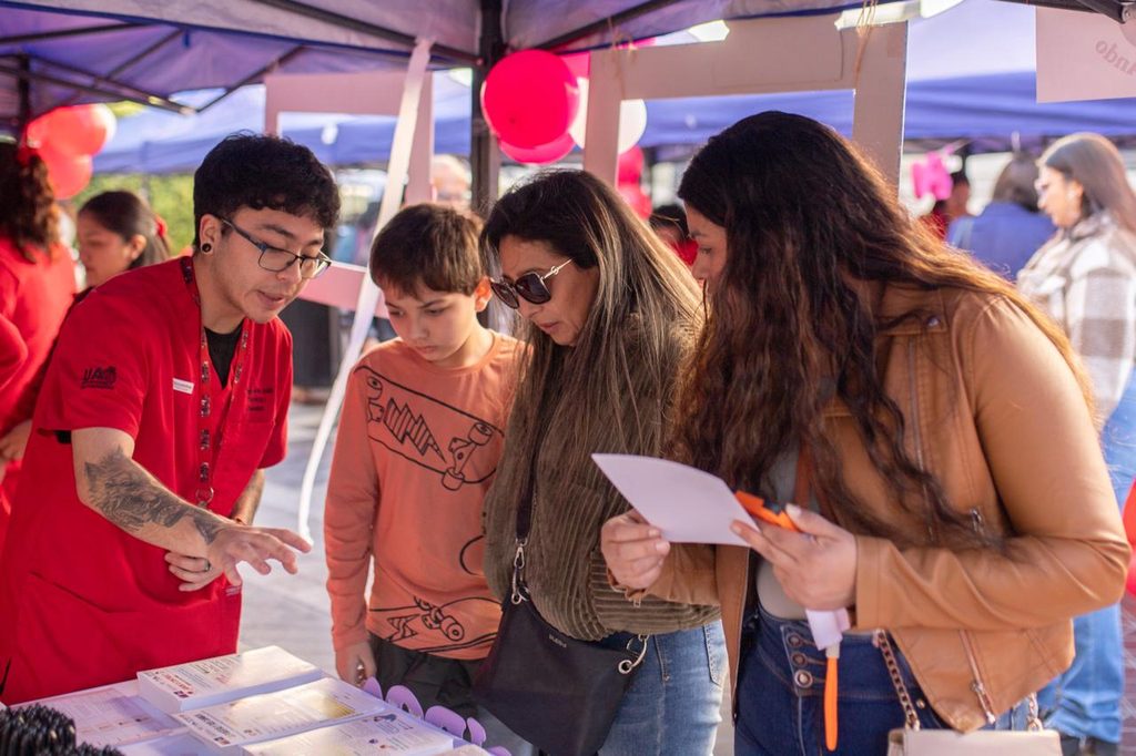 Estudiantes de obstetricia de la Universidad de Antofagasta atendiendo a la comunidad en una feria de salud preventiva.