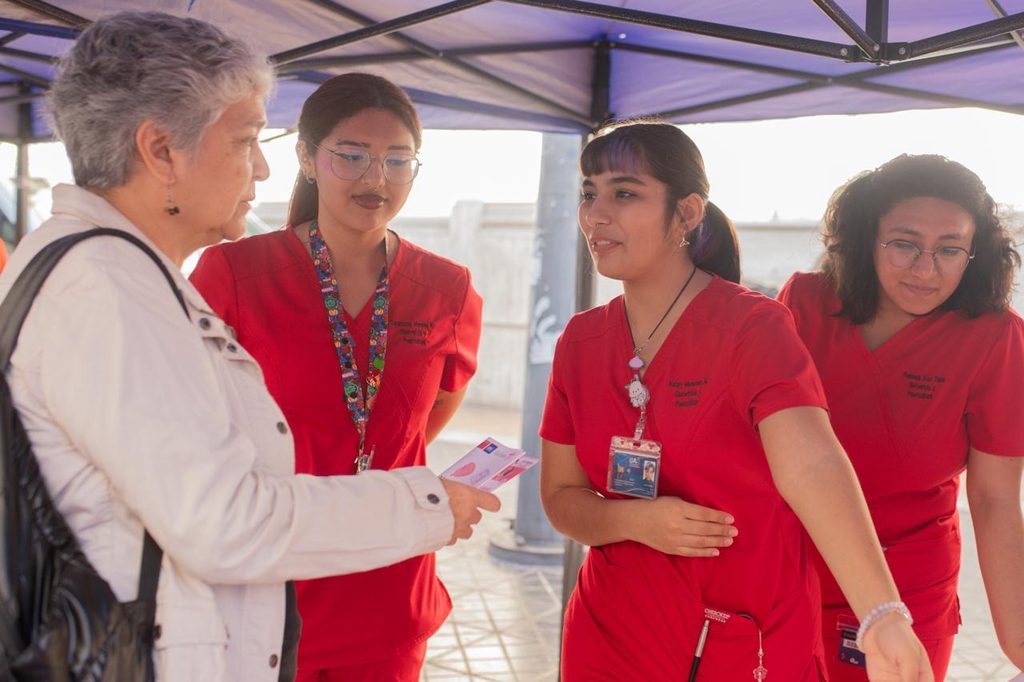 Estudiantes de obstetricia de la Universidad de Antofagasta atendiendo a la comunidad en una feria de salud preventiva.