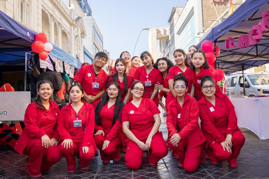 Estudiantes de obstetricia de la Universidad de Antofagasta atendiendo a la comunidad en una feria de salud preventiva.