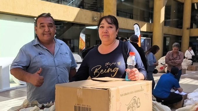 Autoridades municipales de Antofagasta entregando juguetes a representantes vecinales para el Día del Niño.