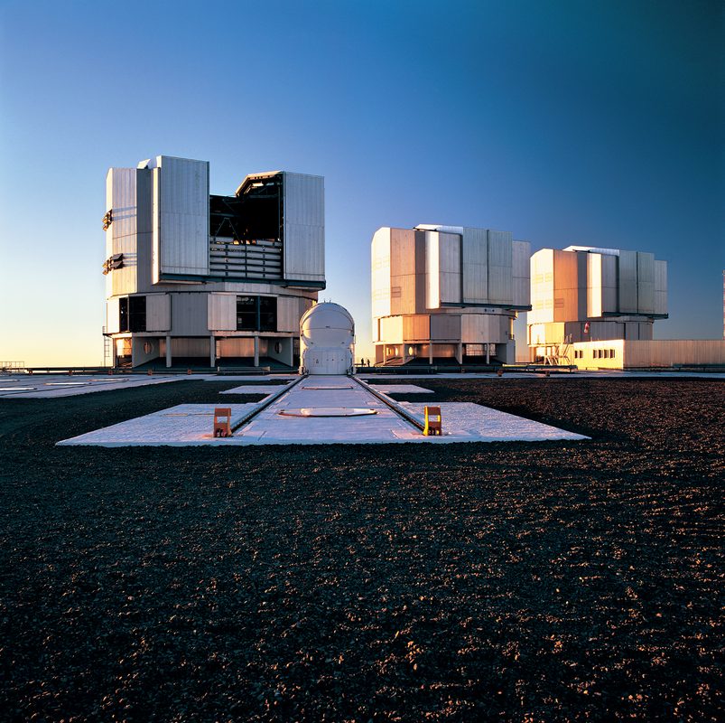 Vista nocturna de los telescopios del Observatorio Paranal bajo un cielo estrellado