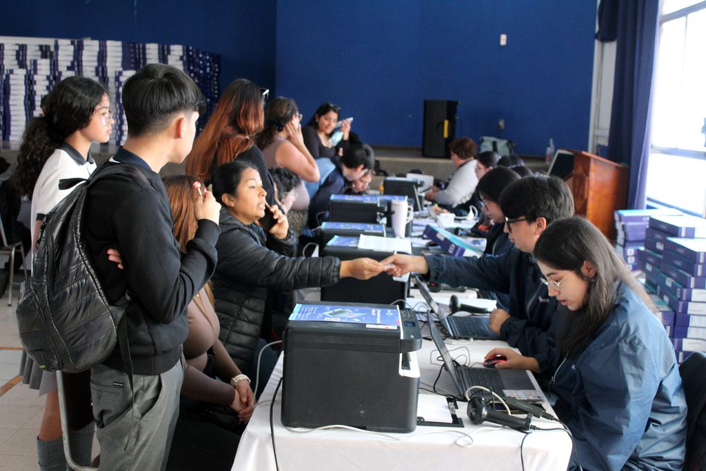 Estudiantes recibiendo computadores portátiles de la Junaeb en la Escuela República del Ecuador en Antofagasta.
