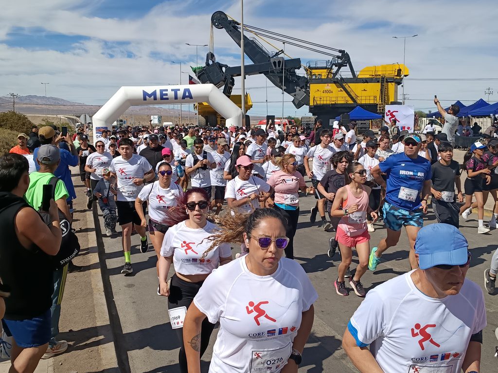 Participantes de la corrida Elige Vivir Sano en Calama celebrando con poleras blancas y entusiasmo