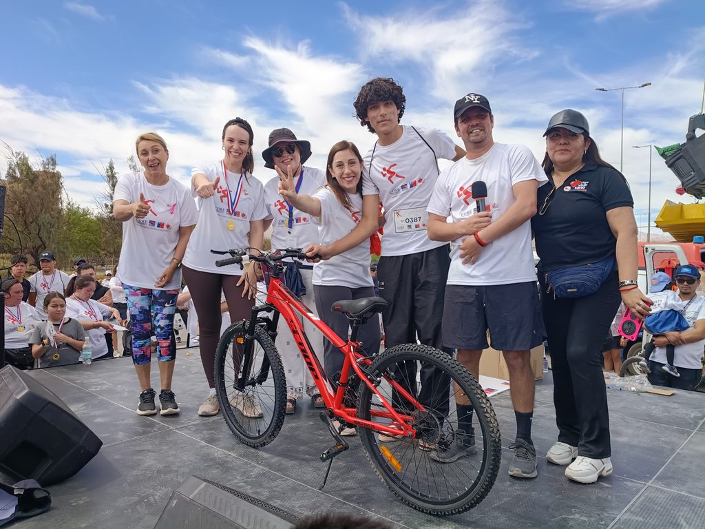 Participantes de la corrida Elige Vivir Sano en Calama celebrando con poleras blancas y entusiasmo