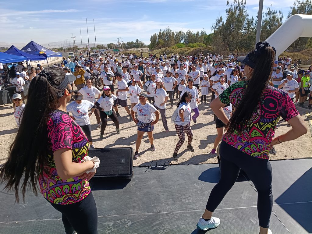 Participantes de la corrida Elige Vivir Sano en Calama celebrando con poleras blancas y entusiasmo